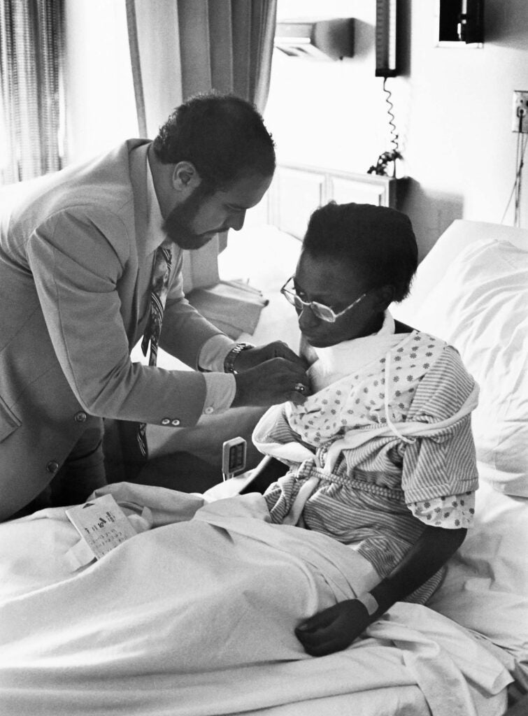 Surgeon Julian Mosley, MD, examines a surgical patient, 1977.