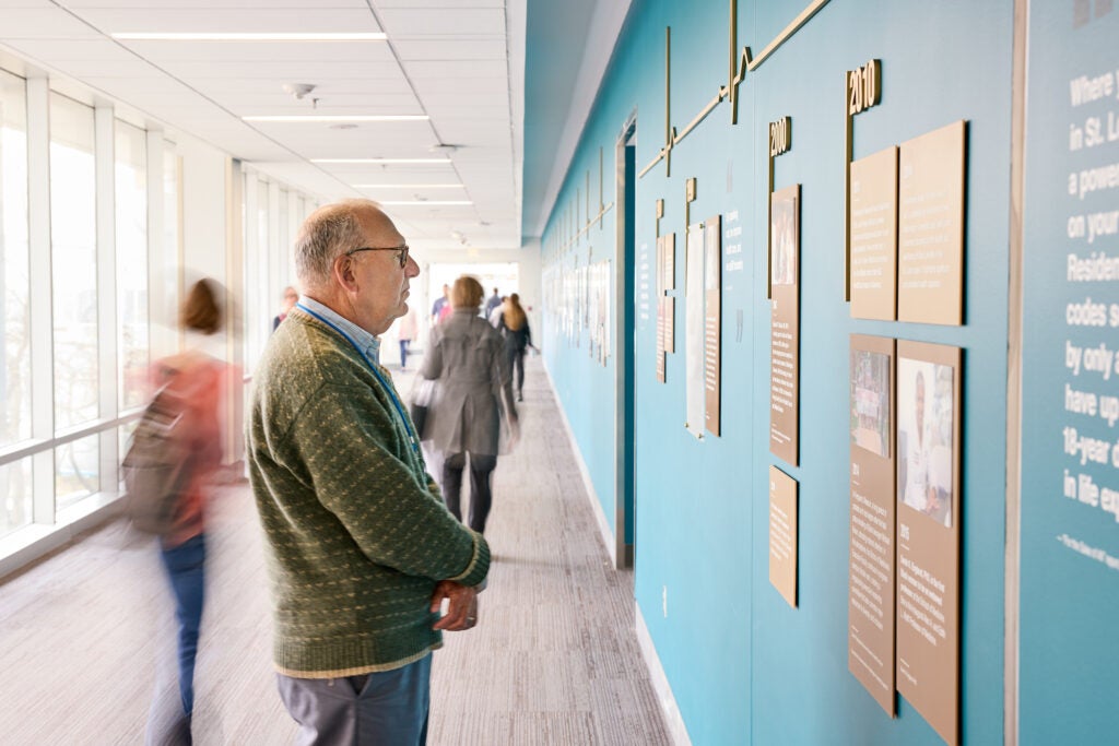 Alan L. Schwartz, MD, PhD, takes time to read the wall and look at the images.